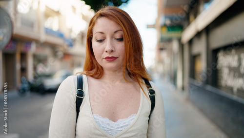 Young redhead woman with relaxed expression standing at street Free Download Young redhead woman with relaxed expression standing at street - GFXLoad