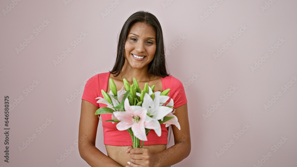 Young latin woman smiling confident holding bouquet of flowers over isolated pink background Young latin woman smiling confident holding bouquet of flowers over isolated pink background