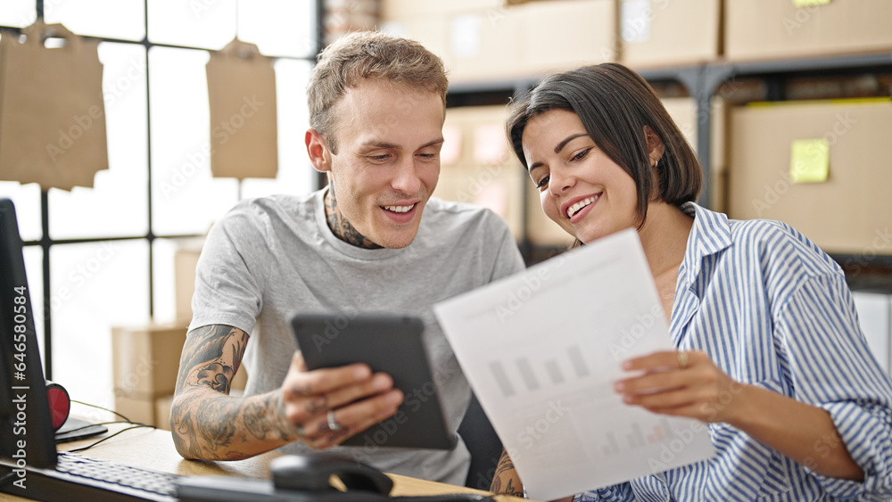 Two ecommerce business workers using touchpad reading document at office Two ecommerce business workers using touchpad reading document at office