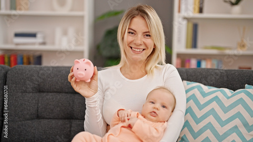Mother and daughter hugging each other holding piggy bank at home