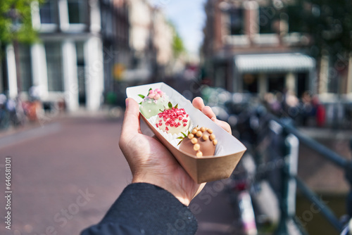  Hand of man holding box with chocolate dessert at amsterdam