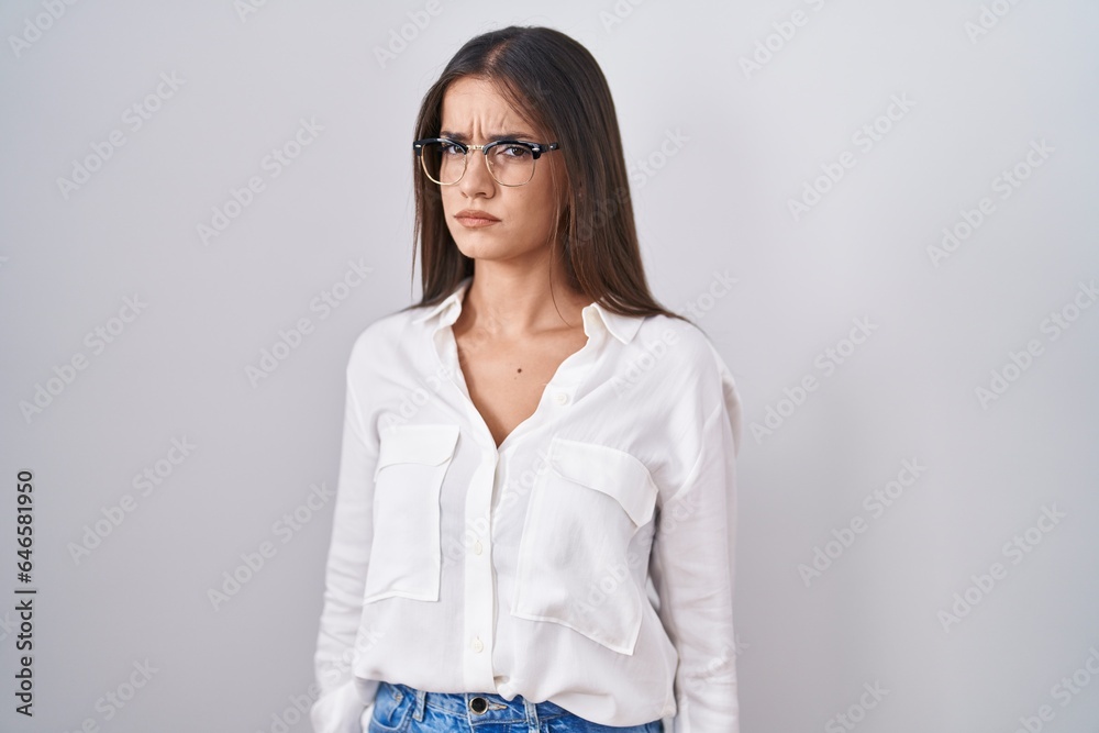 Young brunette woman wearing glasses skeptic and nervous, frowning upset because of problem. negative person. Young brunette woman wearing glasses skeptic and nervous, frowning upset because of problem. negative person.