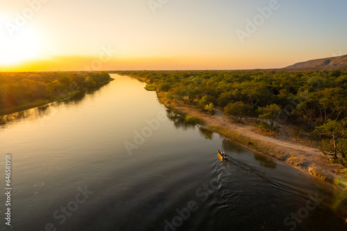 beautiful landscape of boat going up river at sunset