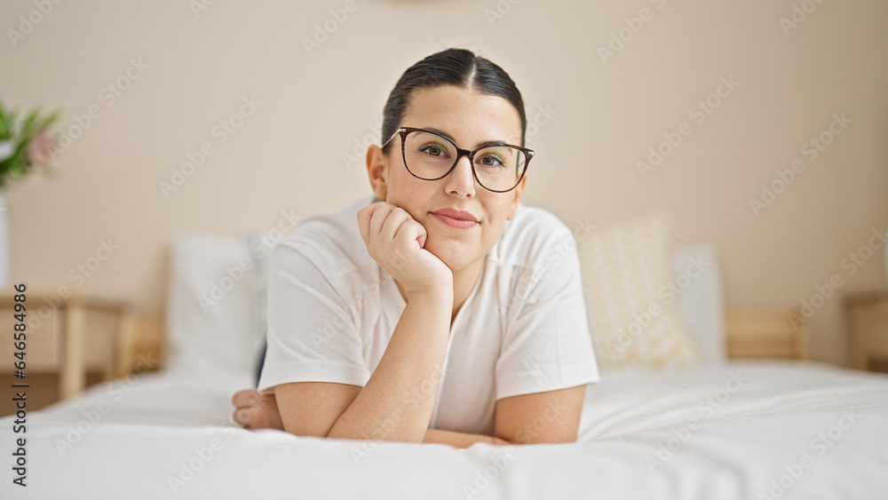 Young beautiful hispanic woman lying on bed smiling at bedroom Young beautiful hispanic woman lying on bed smiling at bedroom