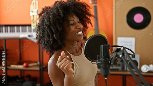 African american woman musician smiling confident singing song at music studio
