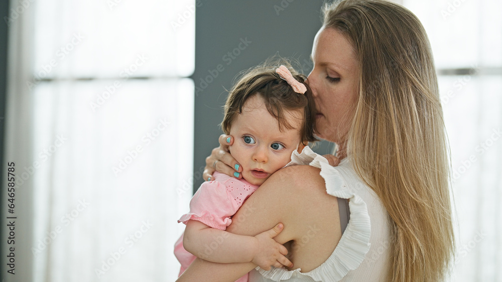 Mother and daughter hugging each other kissing at home Mother and daughter hugging each other kissing at home