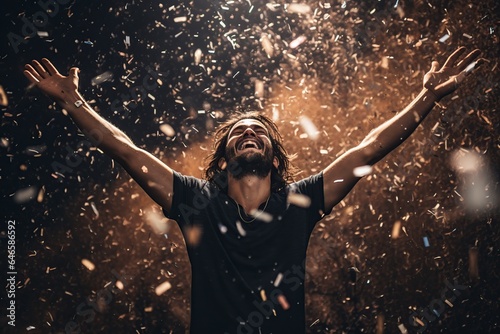 man with his arms in the air and confetti falling
