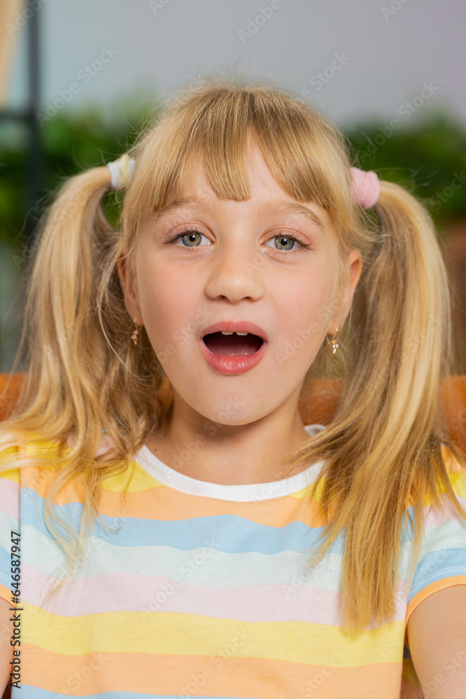 Oh my God, Wow. Surprised preteen school girl looking at camera with big eyes, shocked by sudden victory, good win news, celebrating. Excited amazed child kid at home room sitting on couch. Vertical Oh my God, Wow. Surprised preteen school girl looking at camera with big eyes, shocked by sudden victory, good win news, celebrating. Excited amazed child kid at home room sitting on couch. Vertical