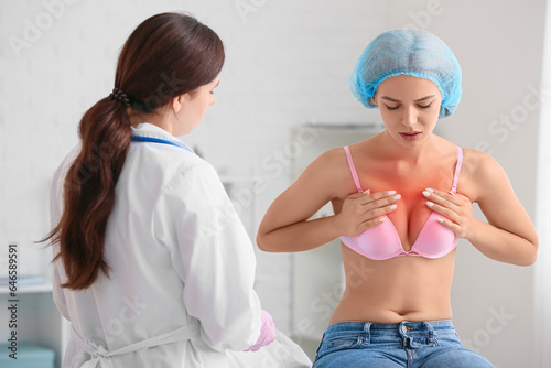 Mammologist examining young woman in clinic. Breast cancer awareness photo