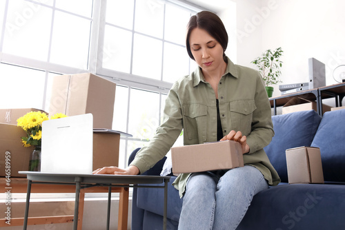 Young woman with parcel usi...