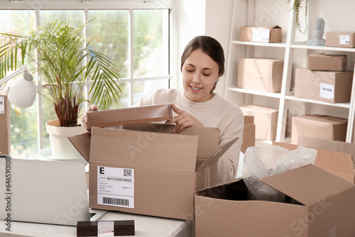 Young woman packing cardboa...