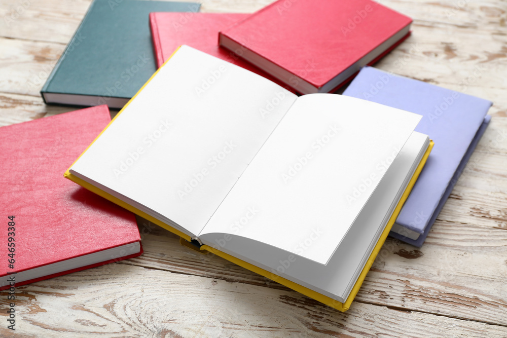 Fototapeta premium Open book with blank pages on white wooden table