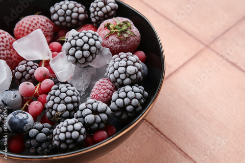 Wallpaper Mural Bowl of frozen berries with ice on color tile background, closeup Torontodigital.ca