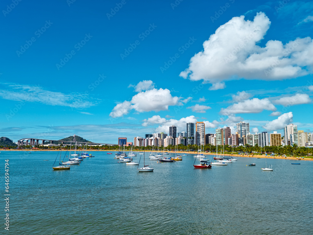 View of the city of Vitoria, capital of  Espirito Santo State, Brazil. Boats in the sea. Beach, buildings, Third bridge and Convent of Penha in the background.