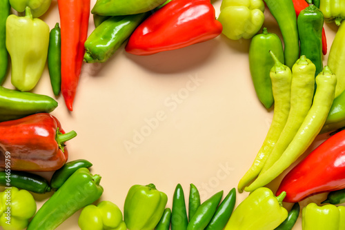 Frame made of different fresh peppers on beige background