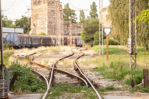 Selective blur on a rusty decaying rail yard and a train switch in a freight railway station, half abandoned, in Smederevo, Serbia, a former cargo and industrial hub of the region.