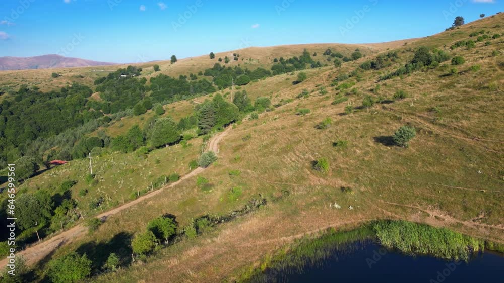Pristine nature, green hills, small water accumulation, backward drone motion view Pristine nature, green hills, small water accumulation, backward drone motion view