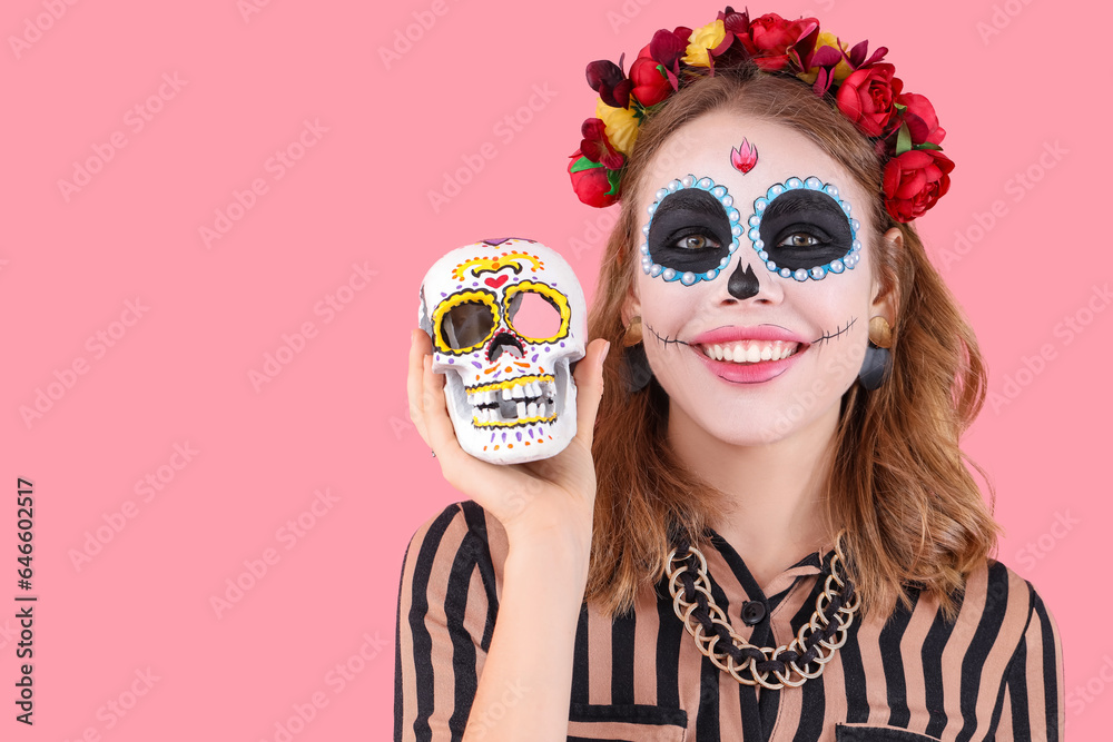 Young woman with painted skull on pink background, closeup. Mexico's Day of the Dead (El Dia de Muertos) celebration Young woman with painted skull on pink background, closeup. Mexico's Day of the Dead (El Dia de Muertos) celebration