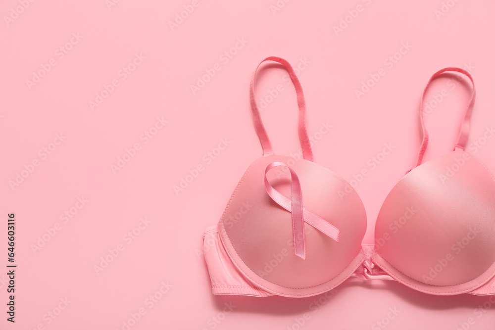 Bra with pink ribbon on color background. Breast cancer awareness concept