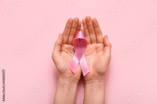 Woman with pink ribbon on color background. Breast cancer awareness concept