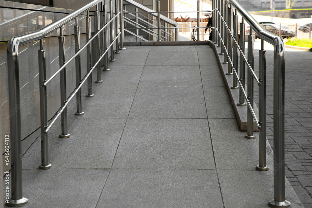 Ramp with metal handrails near building outdoors Ramp with metal handrails near building outdoors
