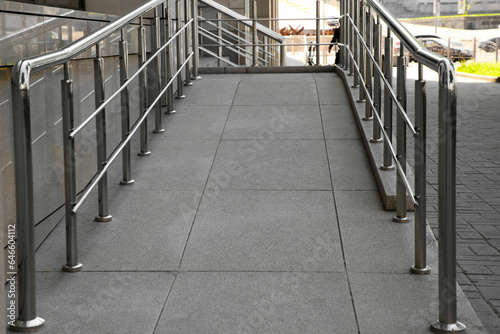 Ramp with metal handrails near building outdoors photo