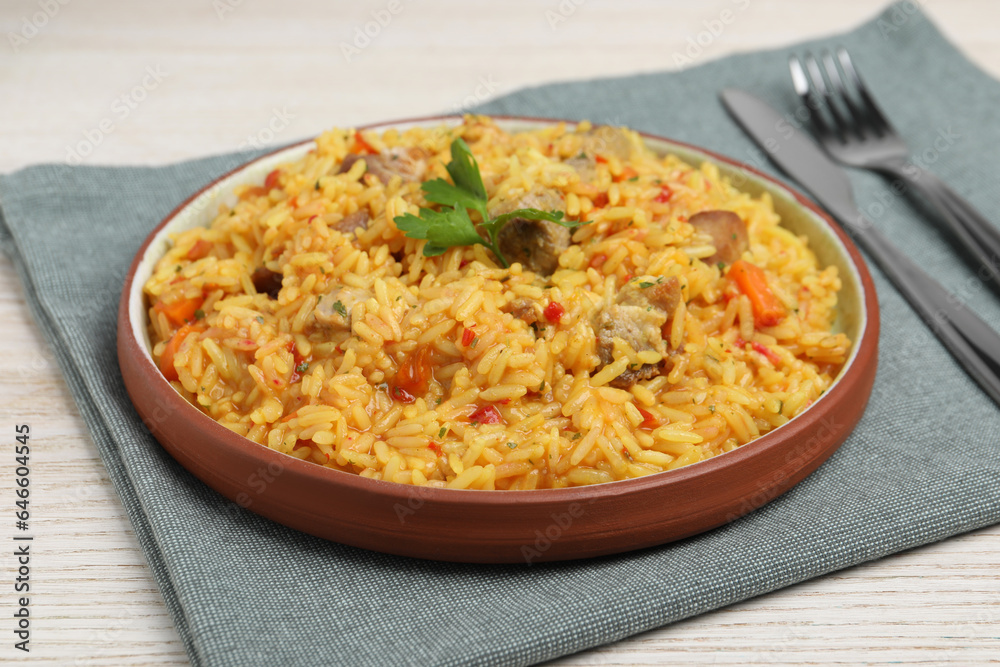 Delicious pilaf with meat served on white wooden table, closeup