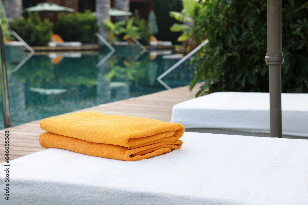 Sun loungers near outdoor swimming pool at luxury resort Sun loungers near outdoor swimming pool at luxury resort