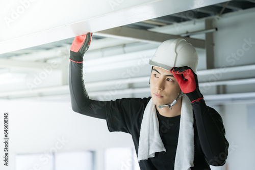 Fotografie Young male worker wearing a helmet at a construction site