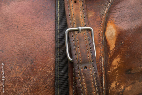 Horse saddle. Detail of the texture, stitching, buckle and leather belt.