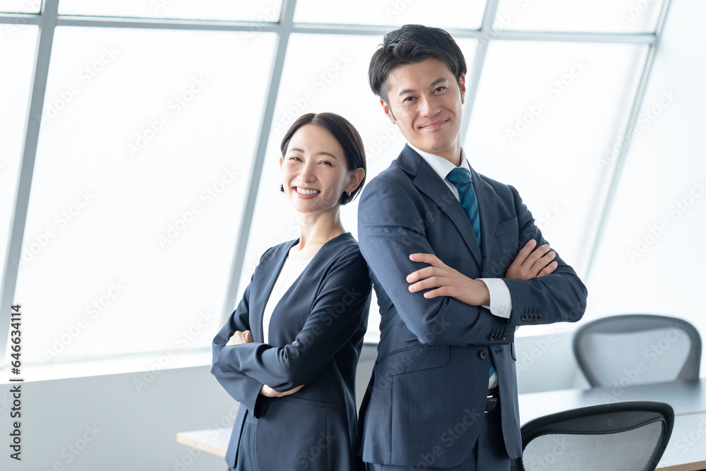 腕組みをする男女　ビジネスシーン