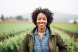 Smiling portrait of a middle aged african american female farmer working on a farm field