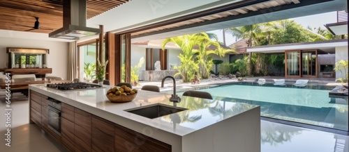 Kitchen area in pool villa with island counter and built-in furniture is designed for interior design.