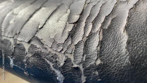 Torn old black leather office chair close up view. Furniture broken and damage concept. Chair moving into focus