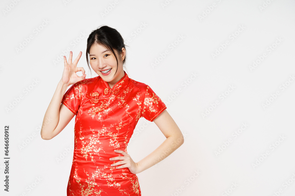 Happy Chinese new year. Asian woman wearing traditional cheongsam qipao dress with gesture of ok hand symbol isolated on white background. Happy Chinese new year. Asian woman wearing traditional cheongsam qipao dress with gesture of ok hand symbol isolated on white background.