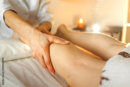 The masseur makes a relaxing foot massage in the wellness spa salon.