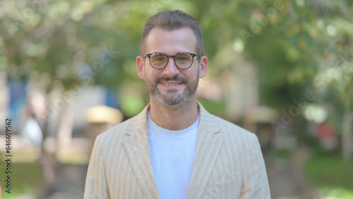 Outdoor Portrait of Acknowledging Middle Aged Man Shaking Head in Acceptance