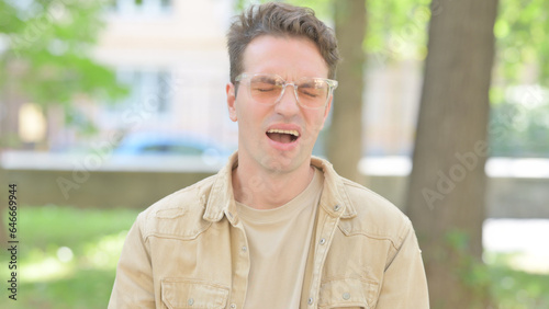 Outdoor Portrait of Upset Casual Young Man Reacting to Failure