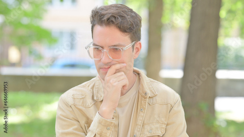 Outdoor Portrait of Brainstorming Casual Young Man with an Idea