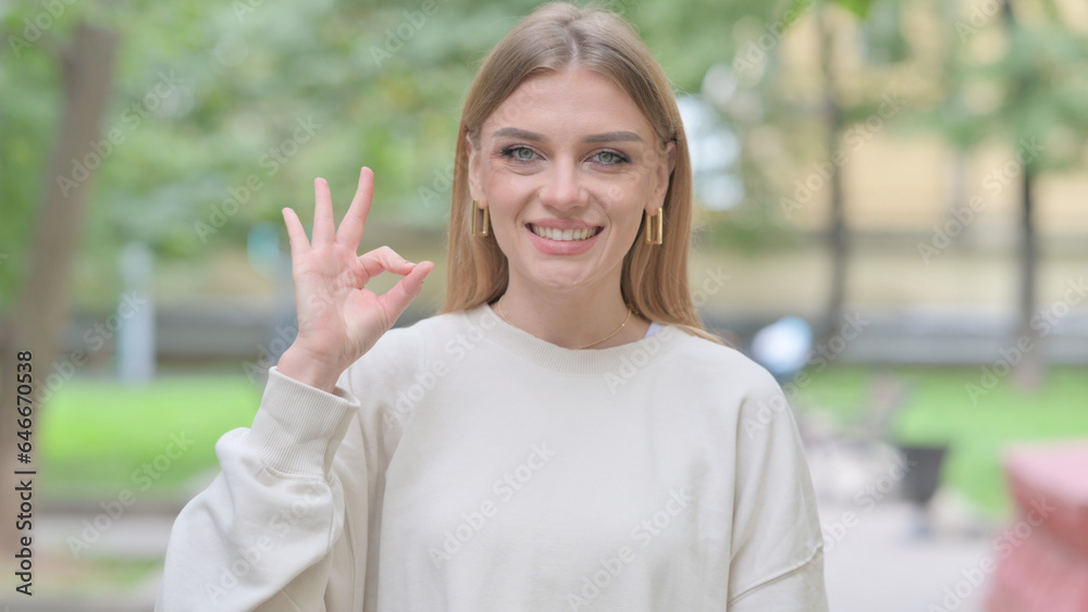 Outdoor Portrait of Woman with Okay Sign