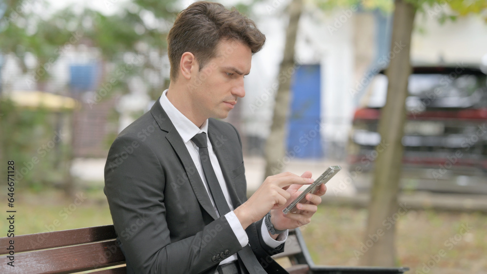 Side View of Pensive Businessman Sitting on Bench Side View of Pensive Businessman Sitting on Bench