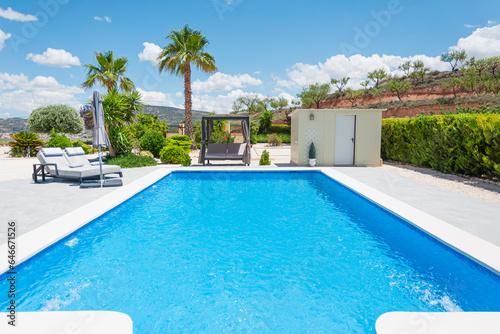 modern villa with swimming pool and sun loungers for relaxation. Beautiful summer landscape