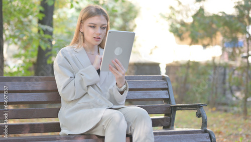 Young Business Lady Doing Video Chat on Tablet while Sitting on Bench on a Bench