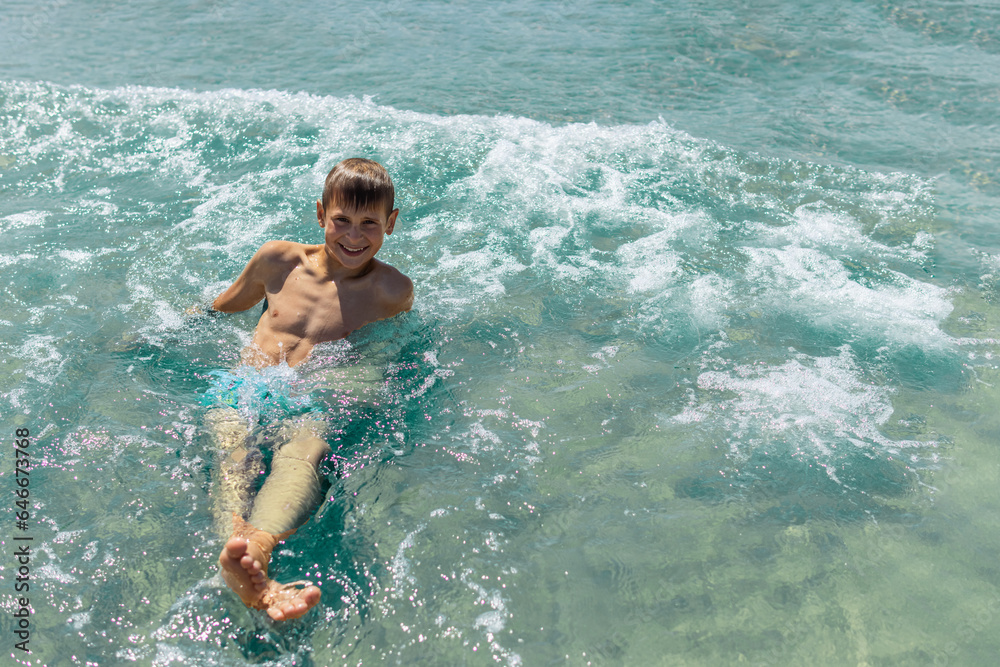 Happy boy swims and dives under water Active healthy lifestyle, water sports, seascape with a child 