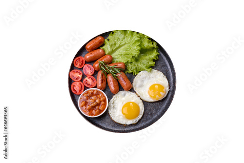 Traditional English breakfast with eggs, toast, sausages, beans, spices and herbs on a grey ceramic plate