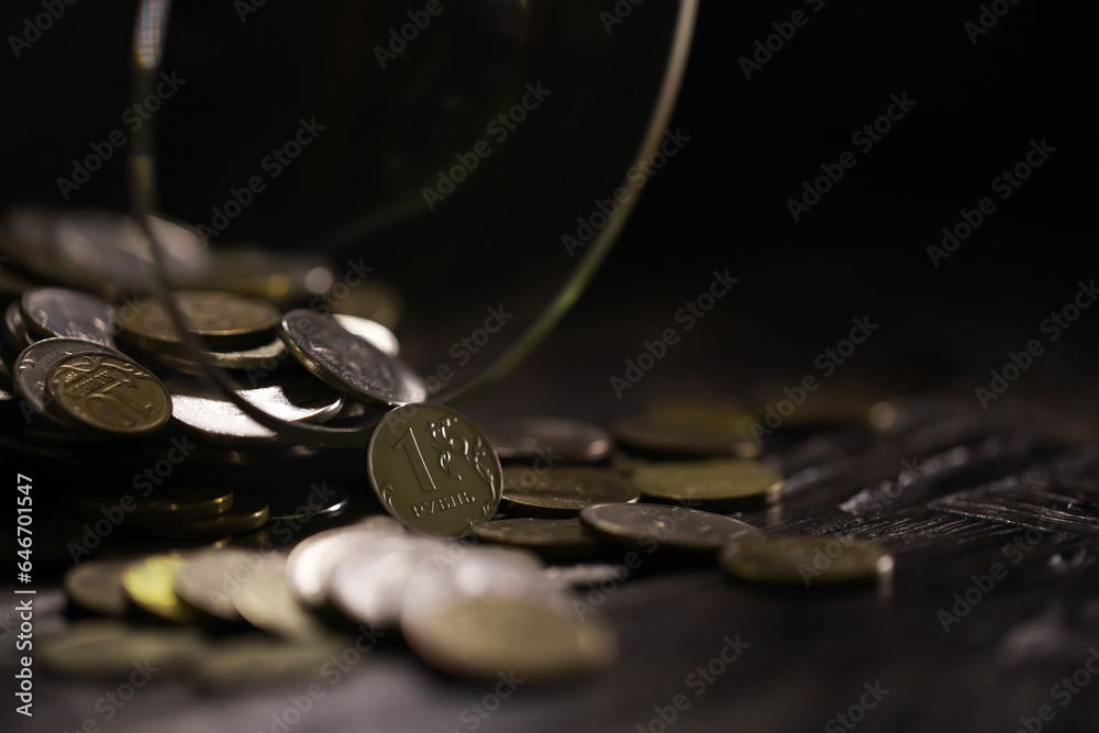 Russian rubles and metal coins inside a glass jar close-up on black blurred background Russian rubles and metal coins inside a glass jar close-up on black blurred background