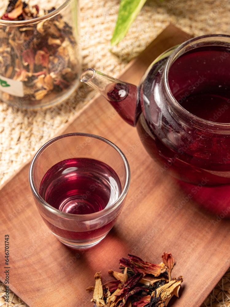 Fresh tea is served in a teapot on a placemat, isolated with a wooden patterned wicker background. Fresh tea is served in a teapot on a placemat, isolated with a wooden patterned wicker background.