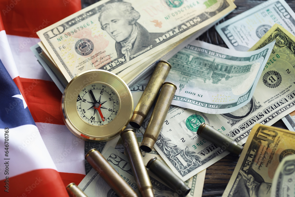 Money bill with golden Compass. Bullets and cartridge cases as a military concept. Close up US Currency and compass. business, financial idea, concept, symbol of crisis, inflation Money bill with golden Compass. Bullets and cartridge cases as a military concept. Close up US Currency and compass. business, financial idea, concept, symbol of crisis, inflation