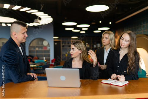 Employee pays close attention to woman sharing valuable insights in coworking office zone. Focused team members take notes for further discussion