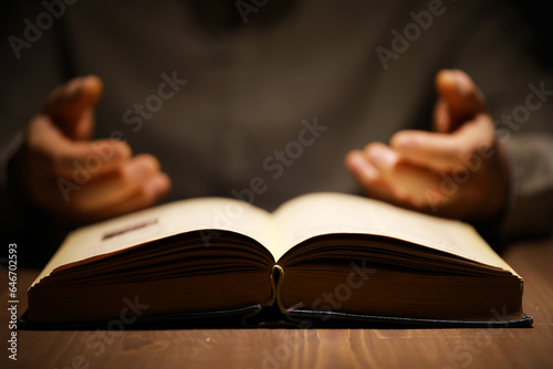 Man holding an open book with two hands. Concept of learning, education, knowledge and religion